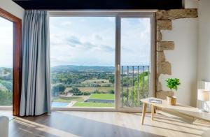 a living room with a large window with a view at Mas Ses Vinyes - Adults Only in Begur