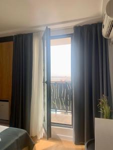 a bedroom with a window with a view of a balcony at Hotel Unirea in Mamaia