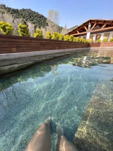 a person laying in the water in a pool at Tradition Corse & Modernité Ì Caseddi dì Barabè Appartement A Cantina in Granace
