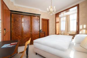 a bedroom with a large bed and a large window at SEETELHOTEL Ahlbecker Hof in Ahlbeck