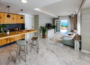 a kitchen and living room with a counter and chairs at Villa The View in Elounda