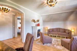 a living room with two couches and a fireplace at Parkhotel Adler in Hinterzarten