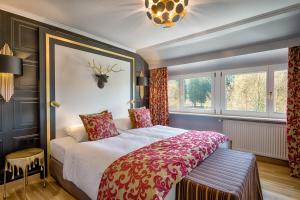 a bedroom with a large bed and a large window at Parkhotel Adler in Hinterzarten