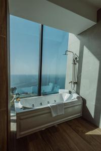 Litz Resort في كفارياتي: حمام مع حوض استحمام مع نافذة كبيرة