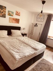 een slaapkamer met een bed en een hanglamp bij Ferienwohnung Horst in Nordenham