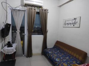 un soggiorno con divano e finestra di Green Pramuka Apartment 2BR a Giacarta