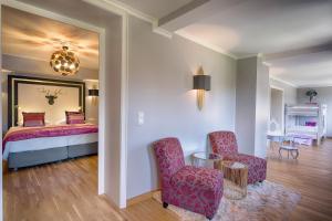 - une chambre avec un lit, deux chaises et une table dans l'établissement Parkhotel Adler, à Hinterzarten