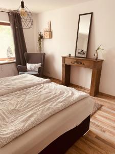 een slaapkamer met een bed, een spiegel en een stoel bij Ferienwohnung Horst in Nordenham