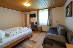 Habitación pequeña con cama y sofá en Gästezimmer Ilse Brauneis en Mautern