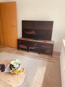 sala de estar con TV y mesa con flores en Ferienwohnung Horst, en Nordenham