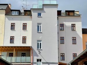 a white building with red windows and a balcony at Penzion u Vlčků in Cheb