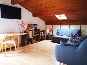 a living room with a blue couch and a bed at maison et table d'hôtes Xori Kanta in Ascain