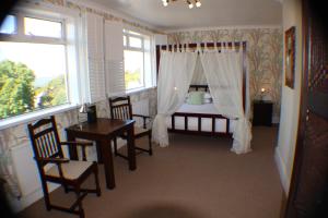 a bedroom with a bed and a table and chairs at The Moorland Hotel in Wotter