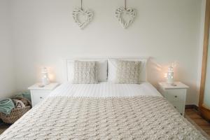 a bedroom with a white bed with two night stands at Radharc na Mara in Doolin