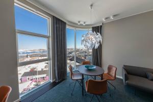 a dining room with a table and chairs and a large window at Best Western Plus Hotel Ilulissat in Ilulissat