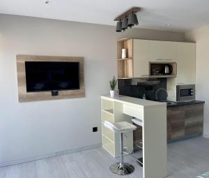 a kitchen with a counter and a tv on the wall at Vila Slap in Vrdnik