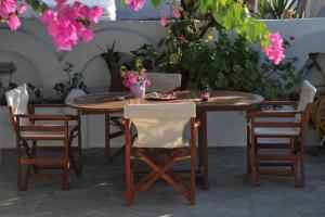 a wooden table and chairs with flowers on it at Barbaras in Naousa