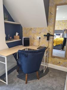 een bureau met een blauwe stoel en een spiegel bij Copperbeech B&B in Yoxford