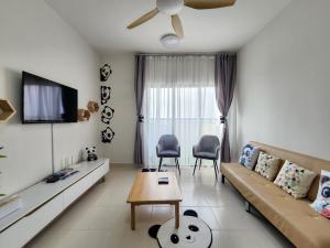 a living room with a couch and a tv at Netflix Panda House 3B2R Rimbayu kota kemuning with Atari games in Teluk Panglima Garang