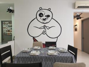 a room with a table with a panda bear on the wall at Netflix Panda House 3B2R Rimbayu kota kemuning with Atari games in Teluk Panglima Garang
