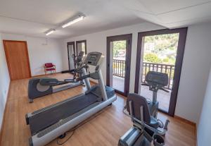 a fitness room with two tread machines and a balcony at Santa Susanna Resort in Santa Susanna