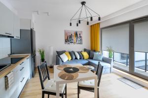 a kitchen and living room with a table and a couch at ALFA 14 in Włocławek