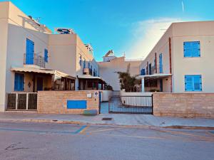 grupa budynków z niebieskimi oknami na ulicy w obiekcie appartamento residence via giardini Acquamarina w mieście San Vito lo Capo