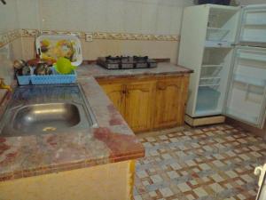 a kitchen with a sink and a refrigerator at Appartement MARTIL BEACH 2 in Martil