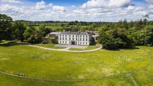an aerial view of a large white house on a green field at 2 Bed Courtyard Apartment at Rockfield House Kells in Meath - Short Term Let in Kells