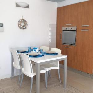 a dining room with a white table and chairs at CASA Chloe' in Lido di Jesolo