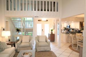 a living room with a couch and chairs and a kitchen at 418 Linkside Drive Home in Destin