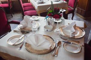 a table with plates and napkins on top of it at San Giovanni Stanly Hotel in Alexandria