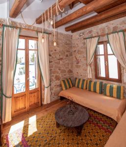 een woonkamer met een bank en een tafel bij Aeolos Guesthouse in Monemvasia
