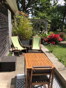 un patio con 2 sillas y una mesa de madera en IBI ENJOY, en Ligné