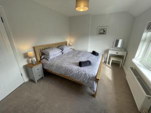 a bedroom with a bed and a television and a window at Coastal getaway in Heacham in Heacham