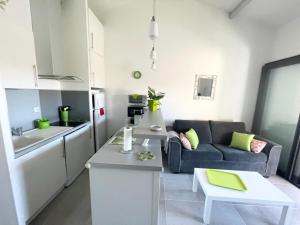 ein Wohnzimmer mit einem blauen Sofa und einer Küche in der Unterkunft Bel appartement à 300 mètres de la plage +parking in Valras-Plage