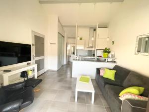 ein Wohnzimmer mit einem Sofa und einem Tisch in der Unterkunft Bel appartement à 300 mètres de la plage +parking in Valras-Plage