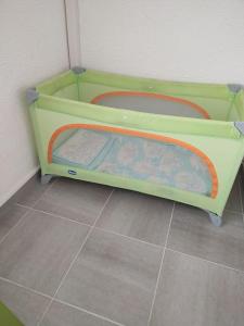ein kleines grünes Bett in einem Zimmer in der Unterkunft Bel appartement à 300 mètres de la plage +parking in Valras-Plage