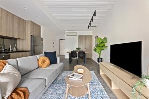 a living room with a couch and a tv at Cinema Suites Apartments by Urban Rest in Sydney