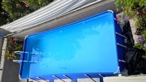 a blue swimming pool in front of a building at Apartments Jasminka in Solin
