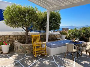 patio ze stołem, krzesłami i drzewem w obiekcie Portobello Boutique Hotel w mieście Mykonos