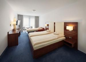 En eller flere senger på et rom på Stadthotel am Wasen