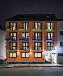 ein Gebäude mit Fenstern und Balkonen in der Nacht in der Unterkunft Stadthotel am Wasen in Stuttgart