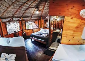 um quarto com 2 camas num quarto com telhado de palha em Raiz Kite Cabana em Jericoacoara