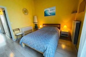 - une chambre avec un lit et un mur jaune dans l'établissement PERLE RARE  DUPLEX - parking gratuit, à Saint-Jean-de-Luz