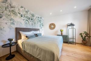 um quarto com uma cama com um grande mural de flores na parede em Videre Lodge Gantkofel em Gargazzone