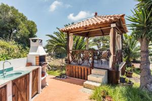 einen Pavillon mit einem Tisch und Stühlen auf einer Terrasse in der Unterkunft Buhardilla Armonia Rural in Granadilla de Abona