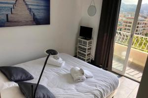 een slaapkamer met een bed en uitzicht op de stad bij Cosy 42m With Balcony Nice View And Wifi in Cannes