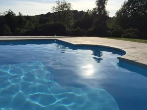 a swimming pool with blue water at LA FONTAINE ROMY in Genneville