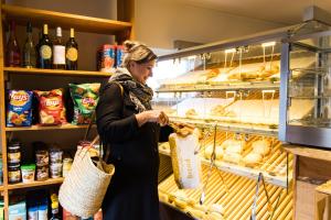 Una mujer está comprando comida en una panadería. en Europarcs De Wije Werelt en Otterlo